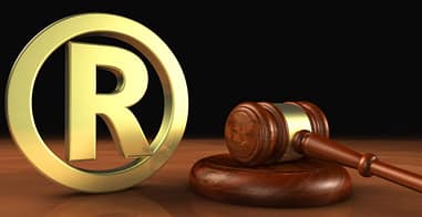 la imagen muestra una R de marca registrada en el escritorio de un abogado litigante en propiedad intelectual marcas patentes derechos de autor